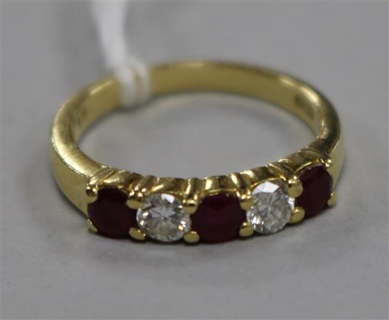 A modern 18ct gold, ruby and diamond five stone half hoop ring, size M/N.